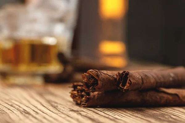 Three rolled cigarillos on wooden table close up — Stock Photo, Image