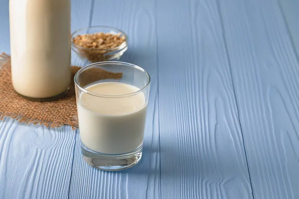 Vegan ovesné mléko s ovesnými vločkami zblízka — Stock fotografie