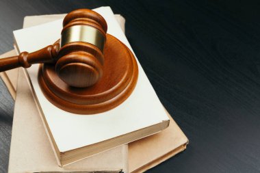 Açık kitabın arka planında kahverengi tahta yargıç tokmağı