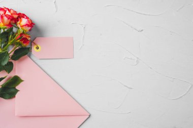 Üzerinde çiçekler olan pembe bir zarf. Romantik mektup