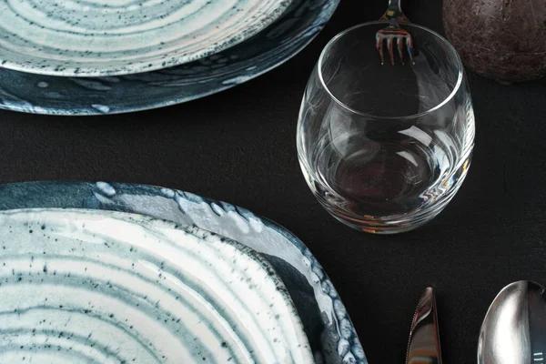Dukning. Tallrikar med abstrakt mönster på svart bord — Stockfoto