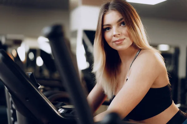 Fit curvy jeune femme blonde formation dans une zone cardio dans une salle de gym — Photo