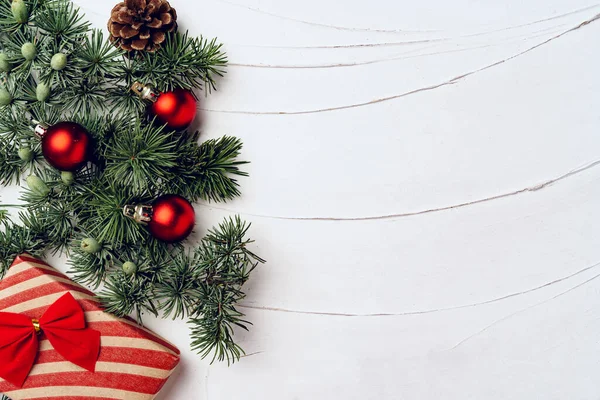 Pin décoré de boules et de cadeaux de Noël enveloppés sur fond de bois blanc — Photo