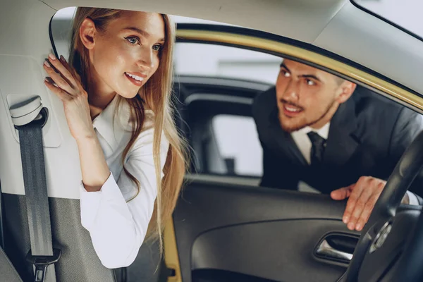 Mann zeigt Autohändler einer Käuferin ein neues Auto — Stockfoto