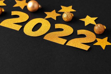 2022 yılı kavramı. Kağıt zemin üzerinde altın yıldızlar ve numaralar 2022