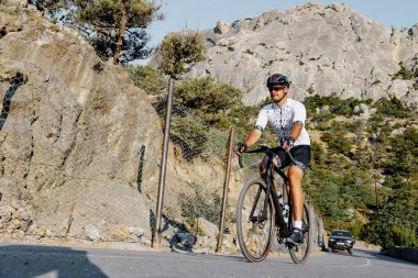 Dağ yolunda profesyonel bir bisiklet yarışçısı var.