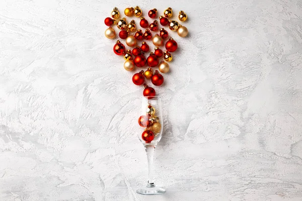 Sektglas mit Weihnachtskugeln flach liegend — Stockfoto