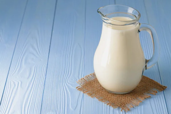 Milk jug on blue wooden background close up — Stock Photo, Image