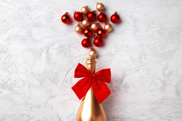 Composición plana con botella de champán de oro y bolas de Navidad —  Fotos de Stock