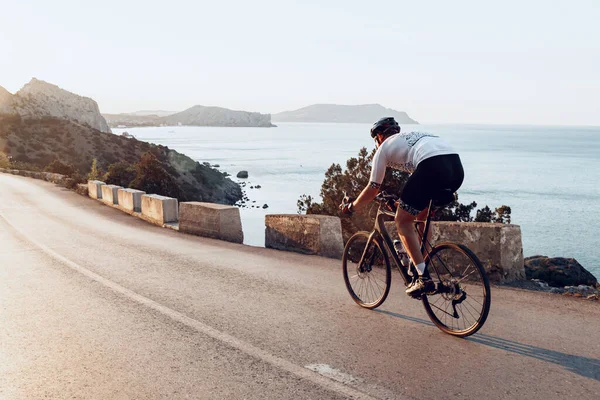 Uomo ciclista pedalando su una bici da strada all'aperto al tramonto — Foto Stock