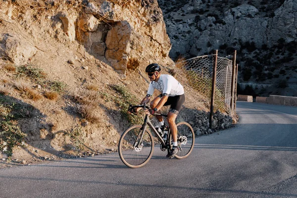 Uomo ciclista pedalando su una bici da strada all'aperto al tramonto — Foto Stock