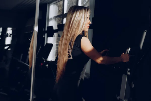 Привлекательная молодая блондинка, тренирующаяся на кардио тренажере — стоковое фото