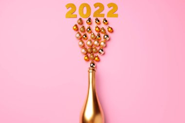 Düz kompozisyon, altın şampanya şişesi ve Noel topları.