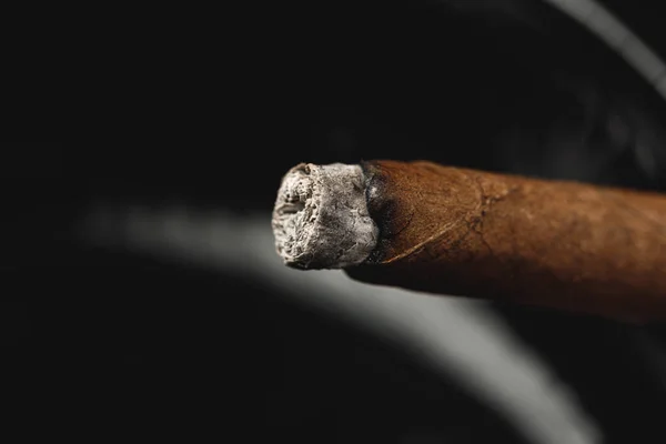 Upplyst cigarr i ett askfat på nära håll — Stockfoto