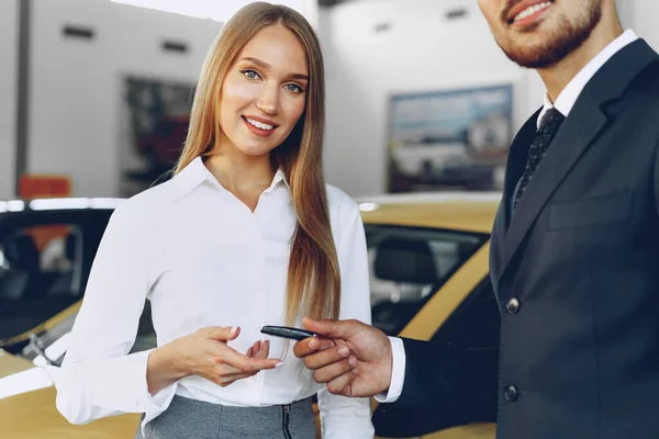 Jovem mulher atraente comprar um carro novo no salão de beleza do carro — Fotografia de Stock