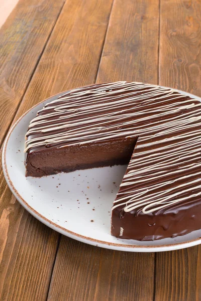 나무 식탁 위에 초콜릿 케이크를 썰어 놓는다 — 스톡 사진