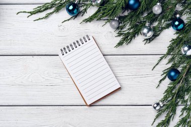 Kozalaklı dalları ve Noel süslemeleri olan beyaz ahşap zemin