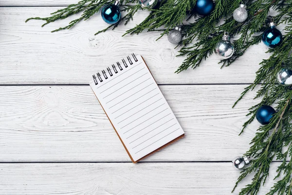 Kozalaklı dalları ve Noel süslemeleri olan beyaz ahşap zemin