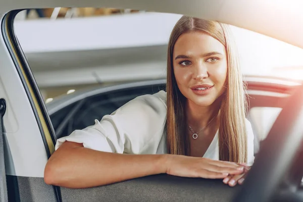 Junge Frau checkt ein neues Auto, das sie kaufen wird — Stockfoto