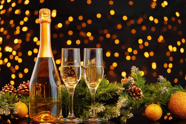 Botella de champán y vasos sobre fondo borroso de luces — Foto de Stock