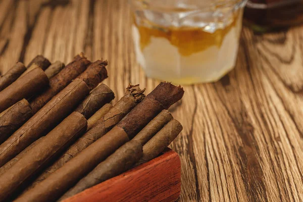 Rote Holzkiste mit aufgerollten Zigarren auf Holztisch in Großaufnahme — Stockfoto