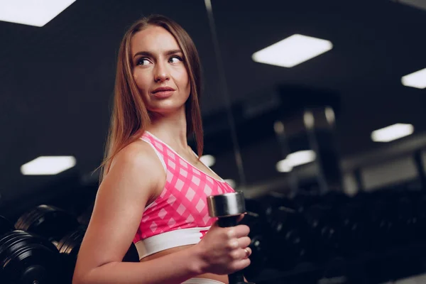 운동복을 입은 젊은 여자가 체육관에서 포즈를 취하는 모습 — 스톡 사진