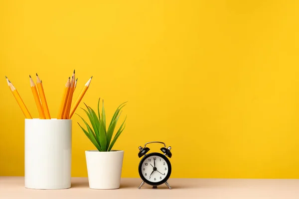 Bürotasse mit Bleistiften und Schreibwaren vor gelbem Hintergrund — Stockfoto