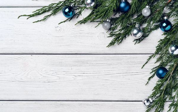 Fundo de madeira branco com ramos de coníferas e decorações de Natal — Fotografia de Stock