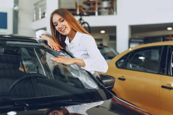 Schöne junge Frau berührt ihr neues Auto mit Vergnügen — Stockfoto