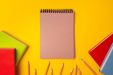 Çalışma alanı üst görünümü üzerine not defteri ve renk kalemleri