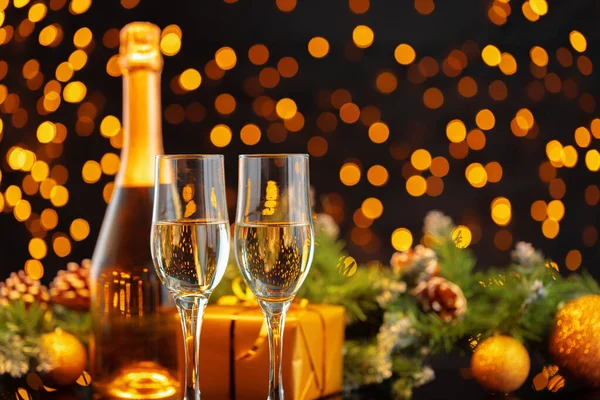 Botella de champán y vasos sobre fondo borroso de luces — Foto de Stock