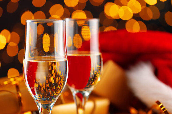 Champagne and Santa Claus hat on blurred garland background
