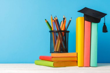 Renkli kalemler ve bir yığın kitap.