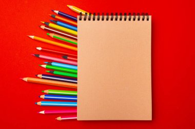 Çalışma alanı üst görünümü üzerine not defteri ve renk kalemleri