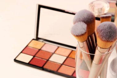 Pembe arka planda dekoratif kozmetik ürünler. Kapat.