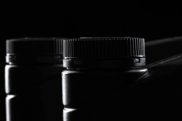 Μπουκαλάκι λαδιού κινητήρα σε μαύρο φόντο, κοντινό. — Φωτογραφία Αρχείου