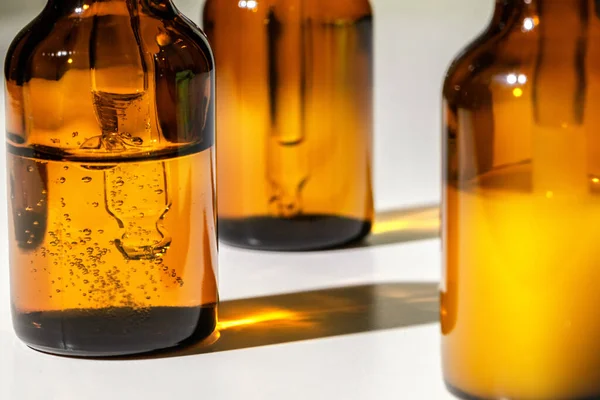 Barna üvegek olajos bőrápoló szérummal közelről — Stock Fotó