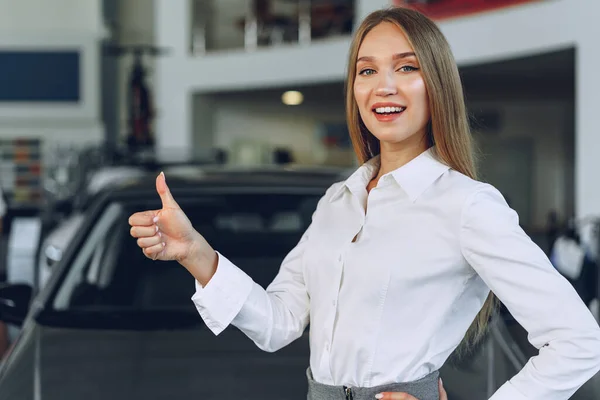 Glücklich schöne junge Autohändlerin im Showroom — Stockfoto