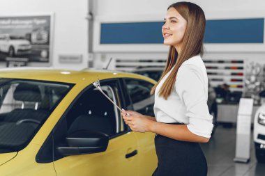 Çekici genç bayan araba satıcısı galeride duruyor.