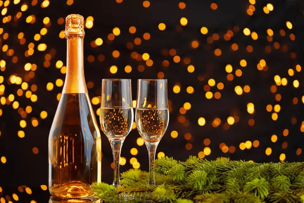 Botella de champán y vasos sobre fondo borroso de luces —  Fotos de Stock