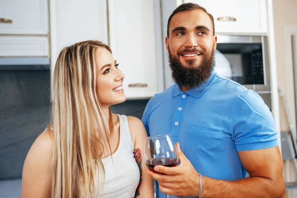 Alegre sonriente pareja cocinar y beber vino en la cocina — Foto de Stock