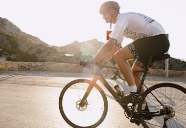 Dağ yolunda profesyonel bir bisiklet yarışçısı var.