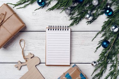 Kozalaklı dalları ve Noel süslemeleri olan beyaz ahşap zemin