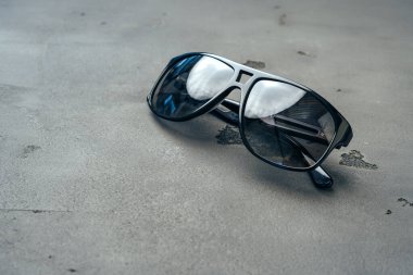 Koyu erkek güneş gözlükleri gri beton yüzeyde