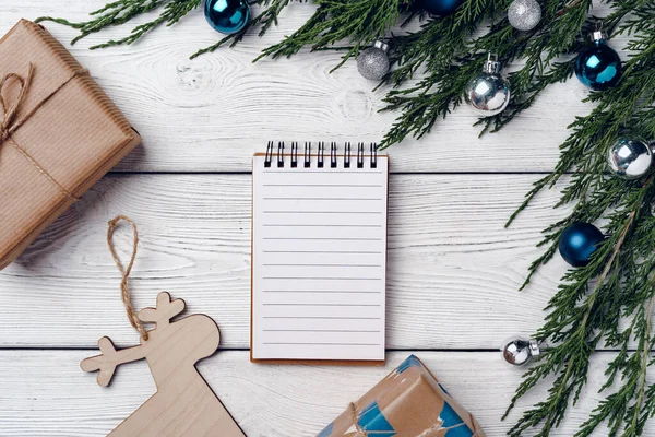 Kozalaklı dalları ve Noel süslemeleri olan beyaz ahşap zemin