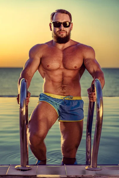 Passform man bodybuilder kommer ur poolen — Stockfoto