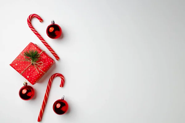 Kerstcadeau met snoepstokken en kerstballen op witte achtergrond — Stockfoto