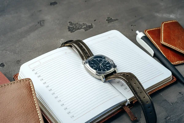 Reloj masculino y bloc de notas sobre mesa gris oscuro — Foto de Stock