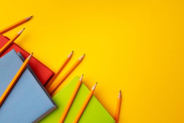 Çalışma alanı üst görünümü üzerine not defteri ve renk kalemleri