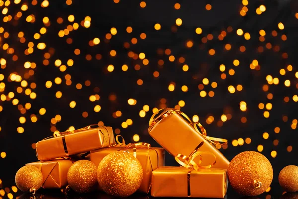 Envuelto regalos de Navidad en luces doradas fondo bokeh —  Fotos de Stock